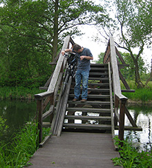 Radler trägt sein rad über eine Stufenbrücke
